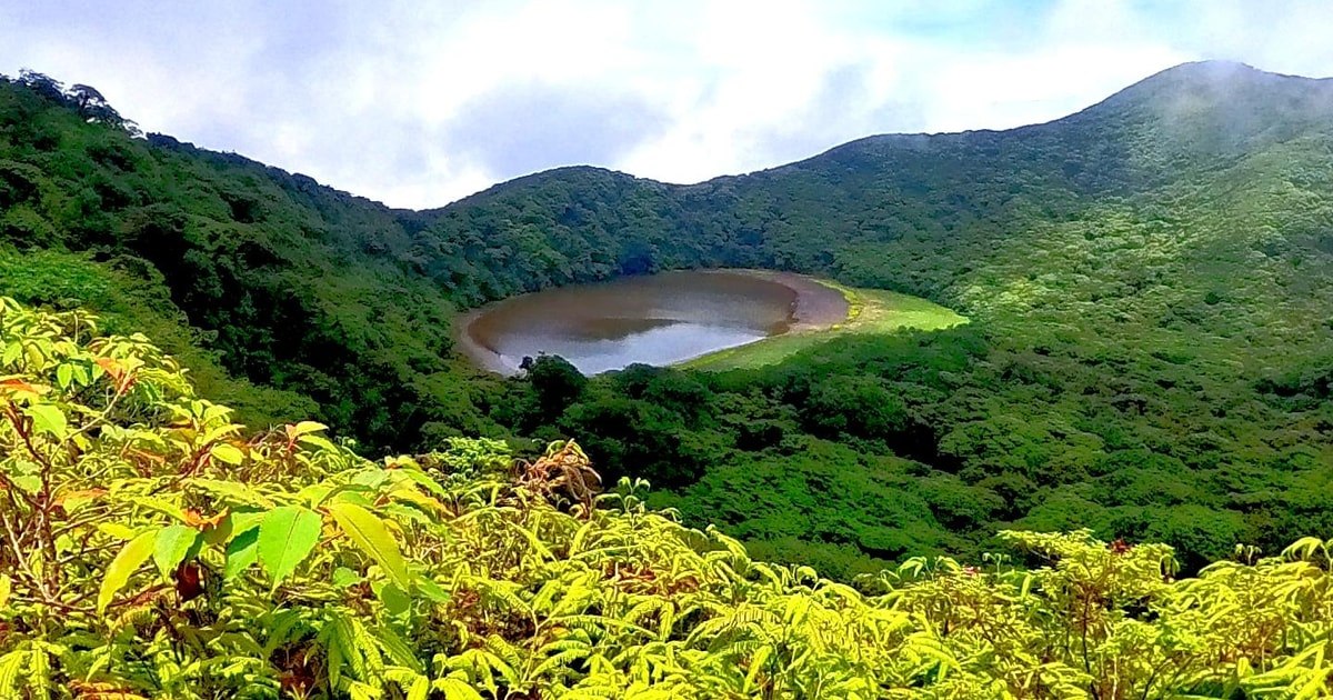 Crater lagoon surrounded by green slopes in the Maderas trek gallery